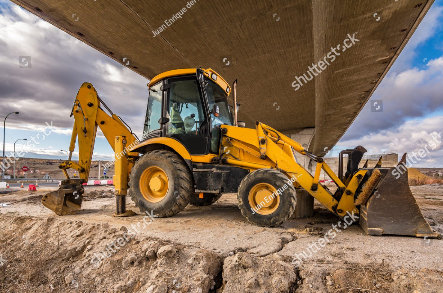 stock-photo-backhoe-in-construction-tasks-of-a-road-preparation-of-the-land-for-the-construction-of-a-bridge-1297518883